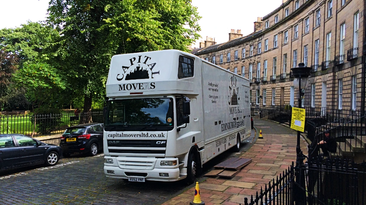 Capital Movers removal truck parked on an Edinburgh street outside a Georgian-style home, ready for a local house move.