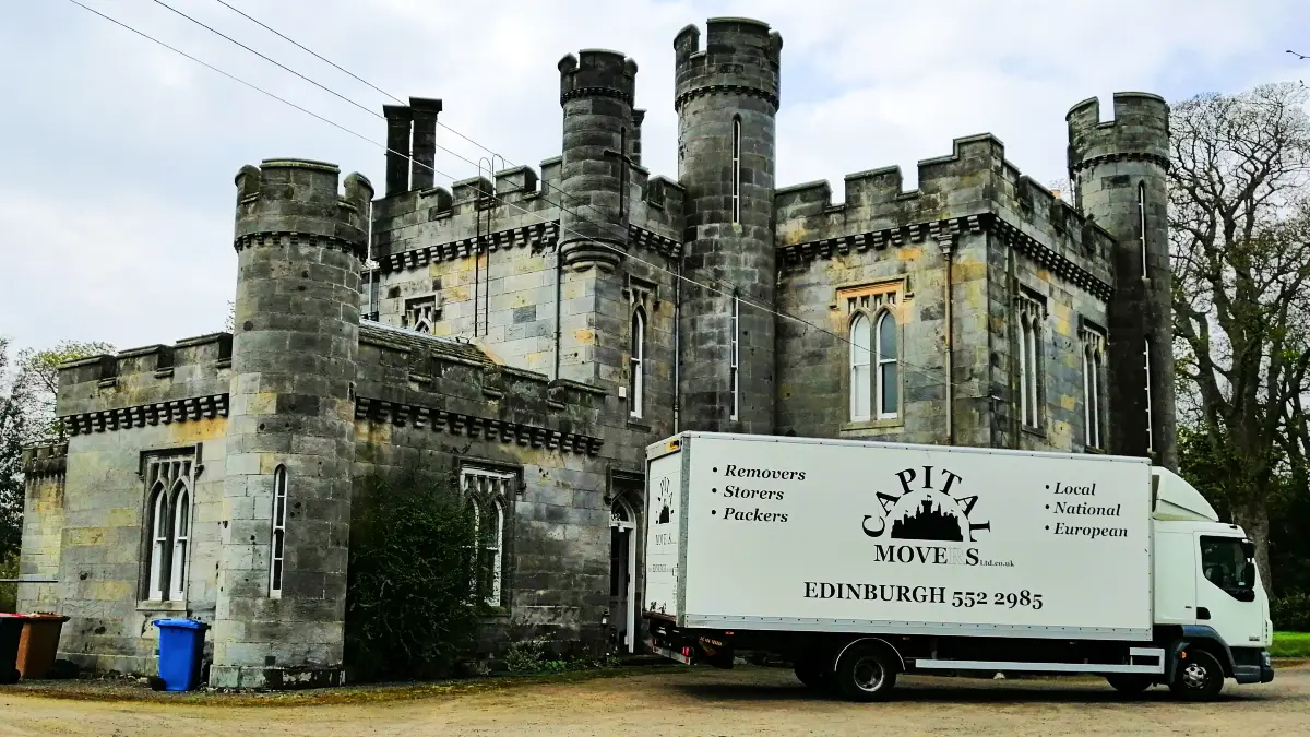 Capital Movers removal truck parked outside a historic Scottish castle in Edinburgh